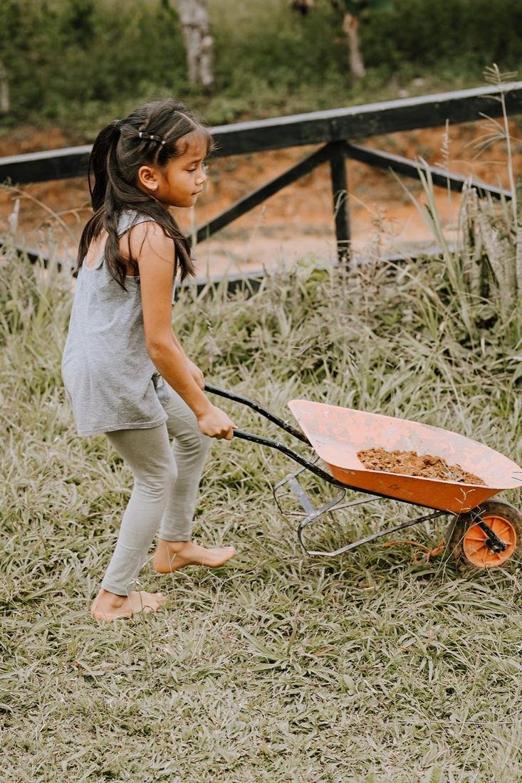 Niña empujando un carretillo durante la jornada
