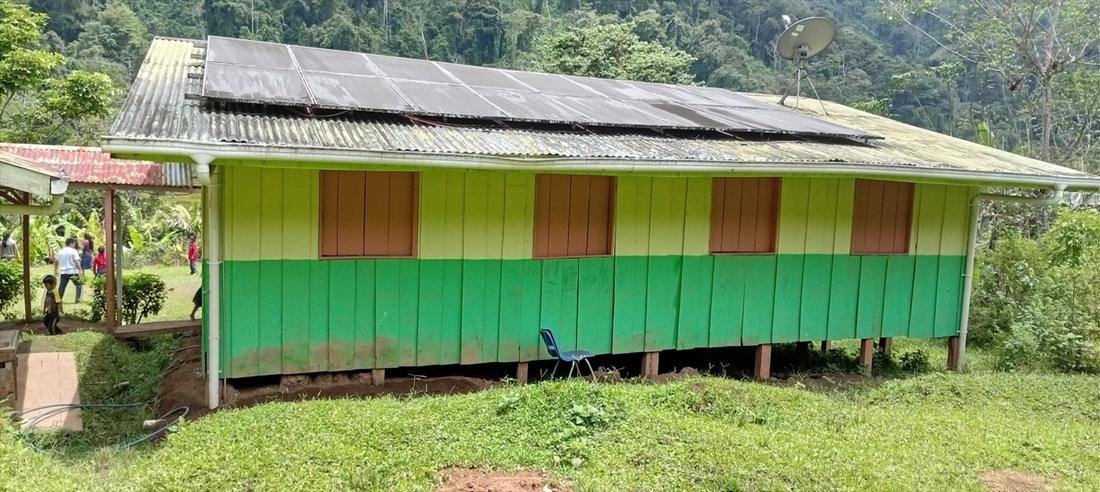 Edificio de la escuela Duseriñak pintado de verde, sobre pilotes